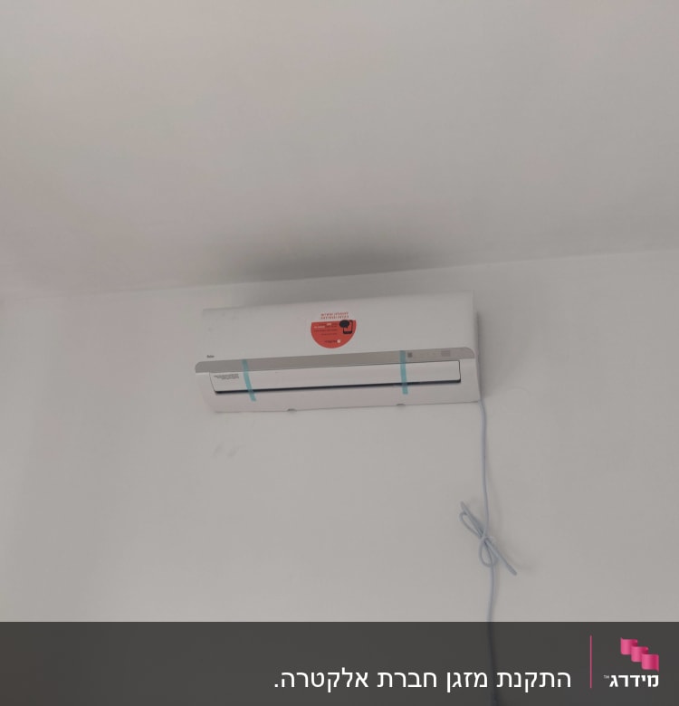 מזגן מותקן על קיר עם כבל חשמל